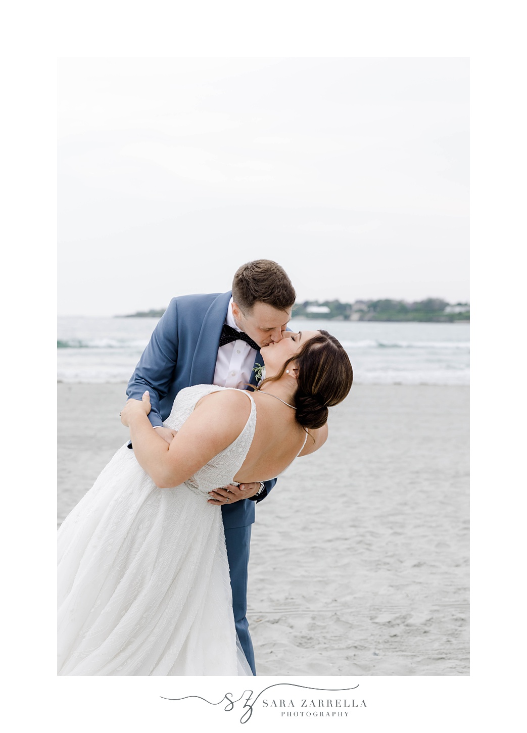 groom dips bride kissing her on Newport Beach