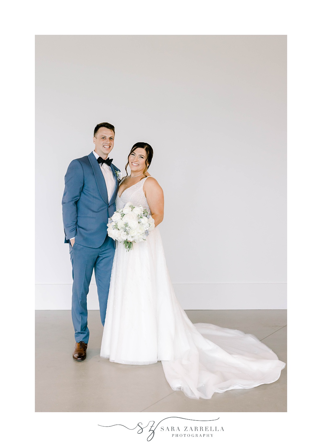 bride and groom stand together in front of white wall in Newport Beach House