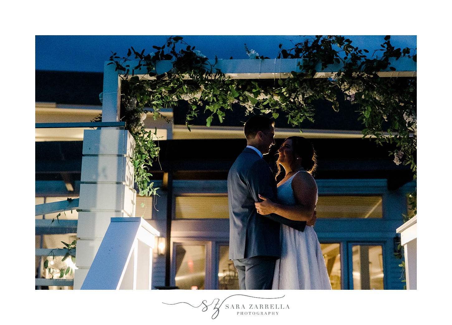 newlyweds kiss outside Newport Beach House at sunset