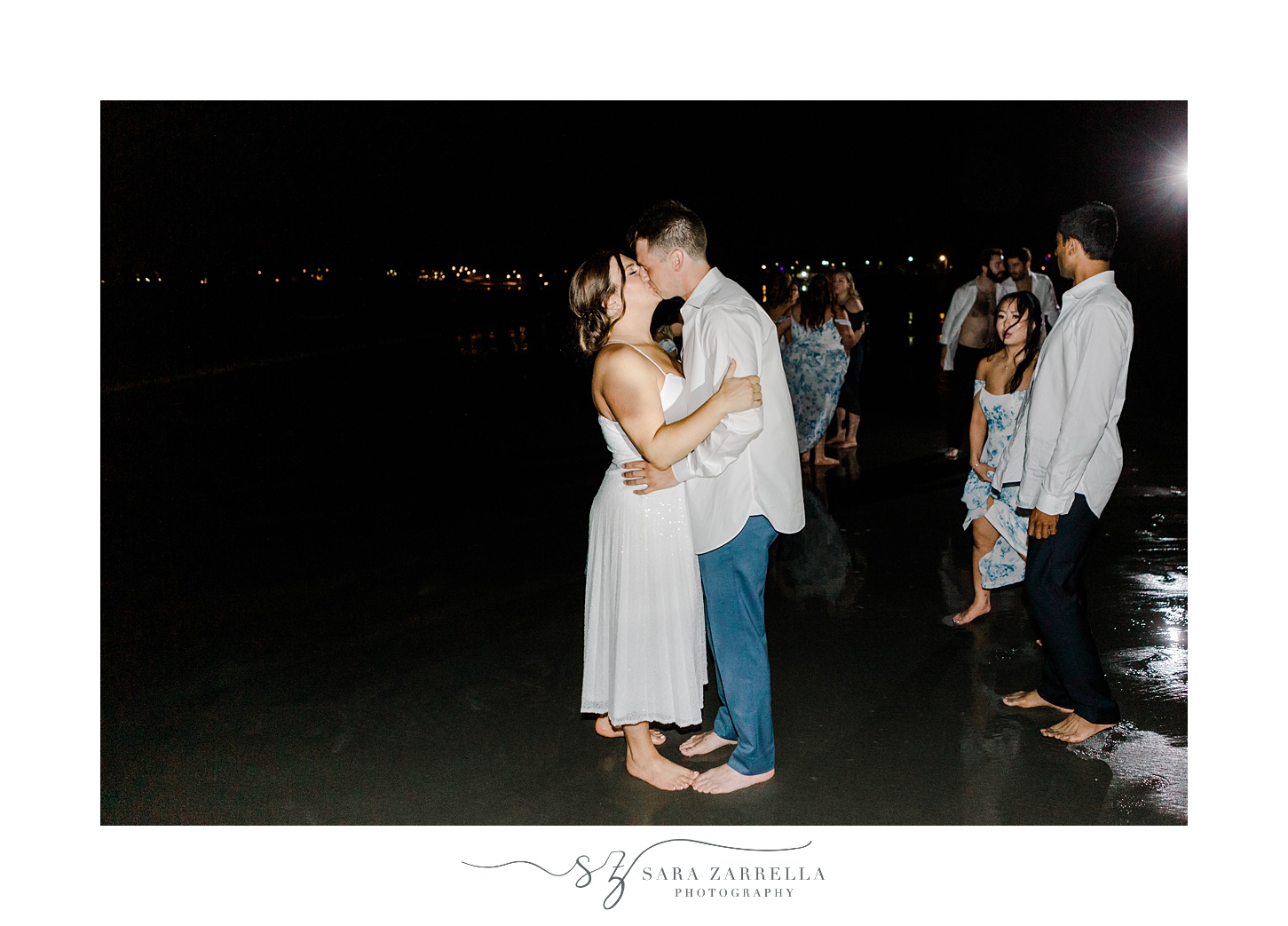 bride and groom kiss after running into ocean in Newport RI