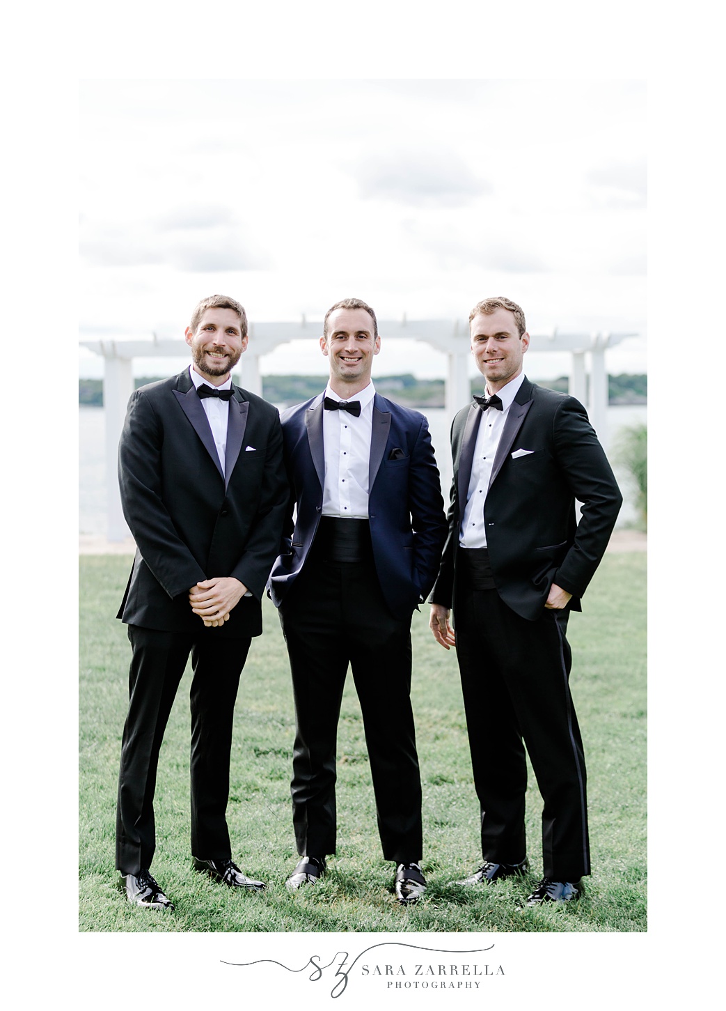 groom stands with groomsmen in tuxes in Newport RI