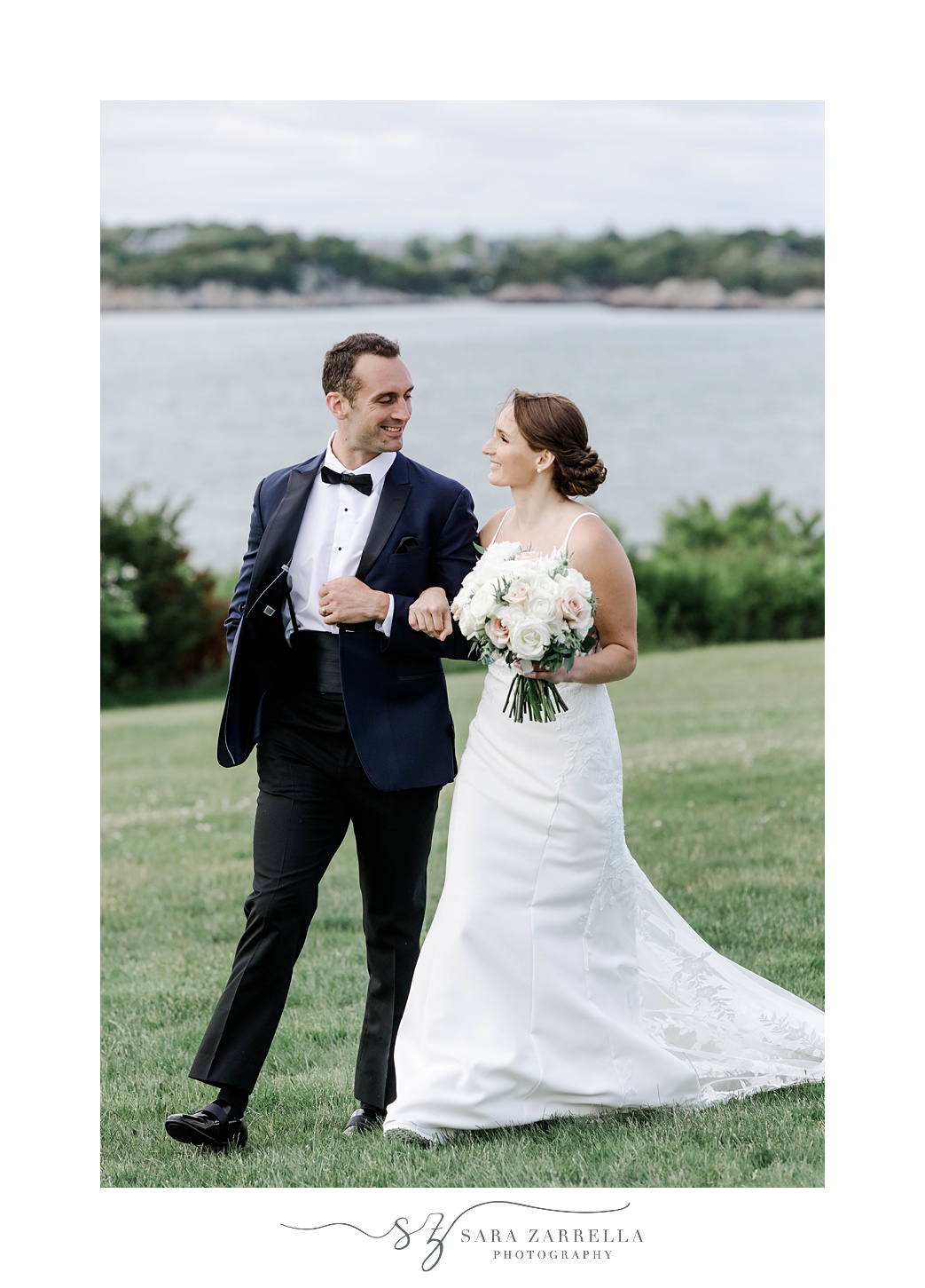 bride smiles at groom holding his arm in Newport RI