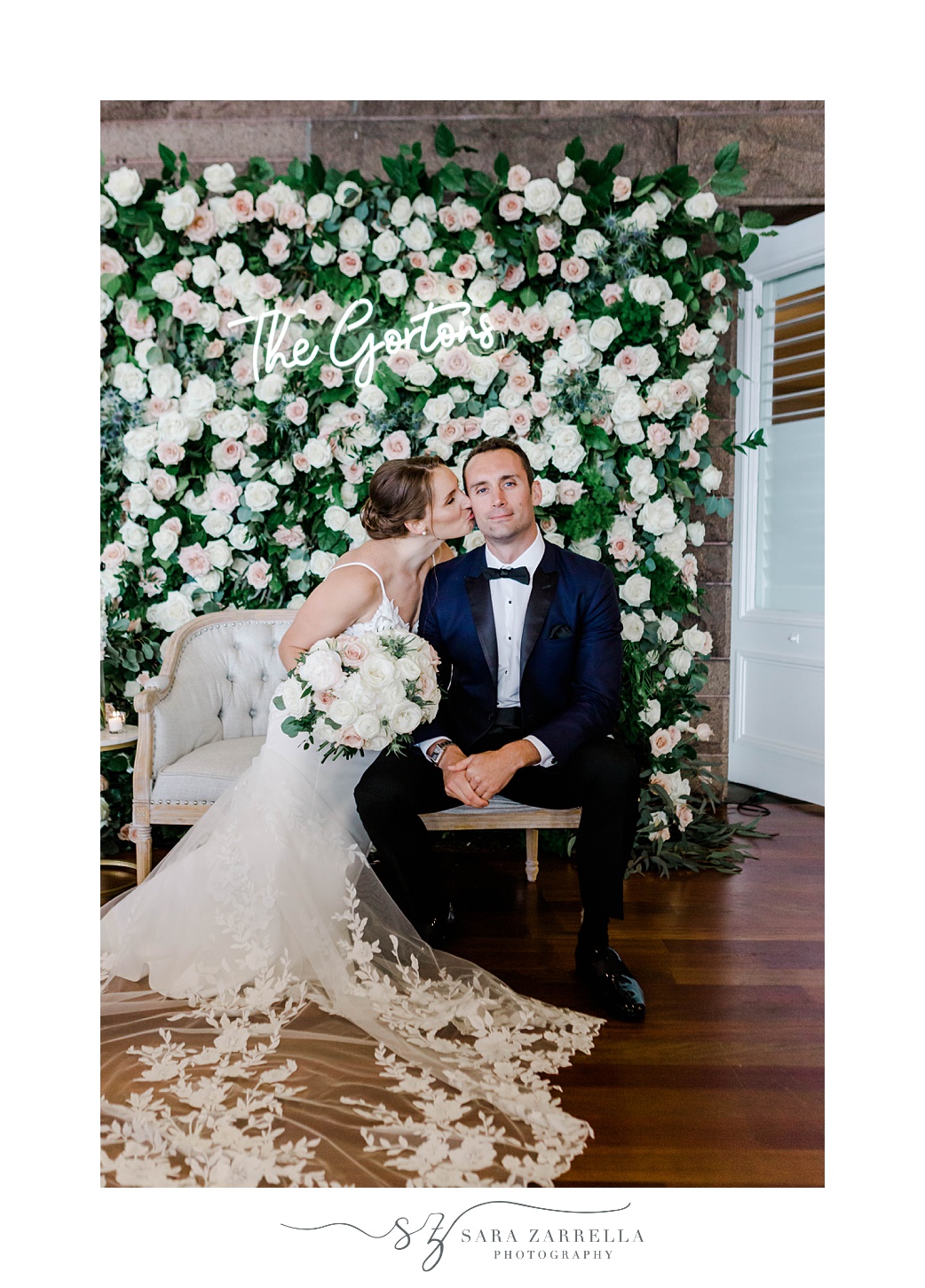 bride and groom sit in front of rose flower wall at OceanCliff Hotel