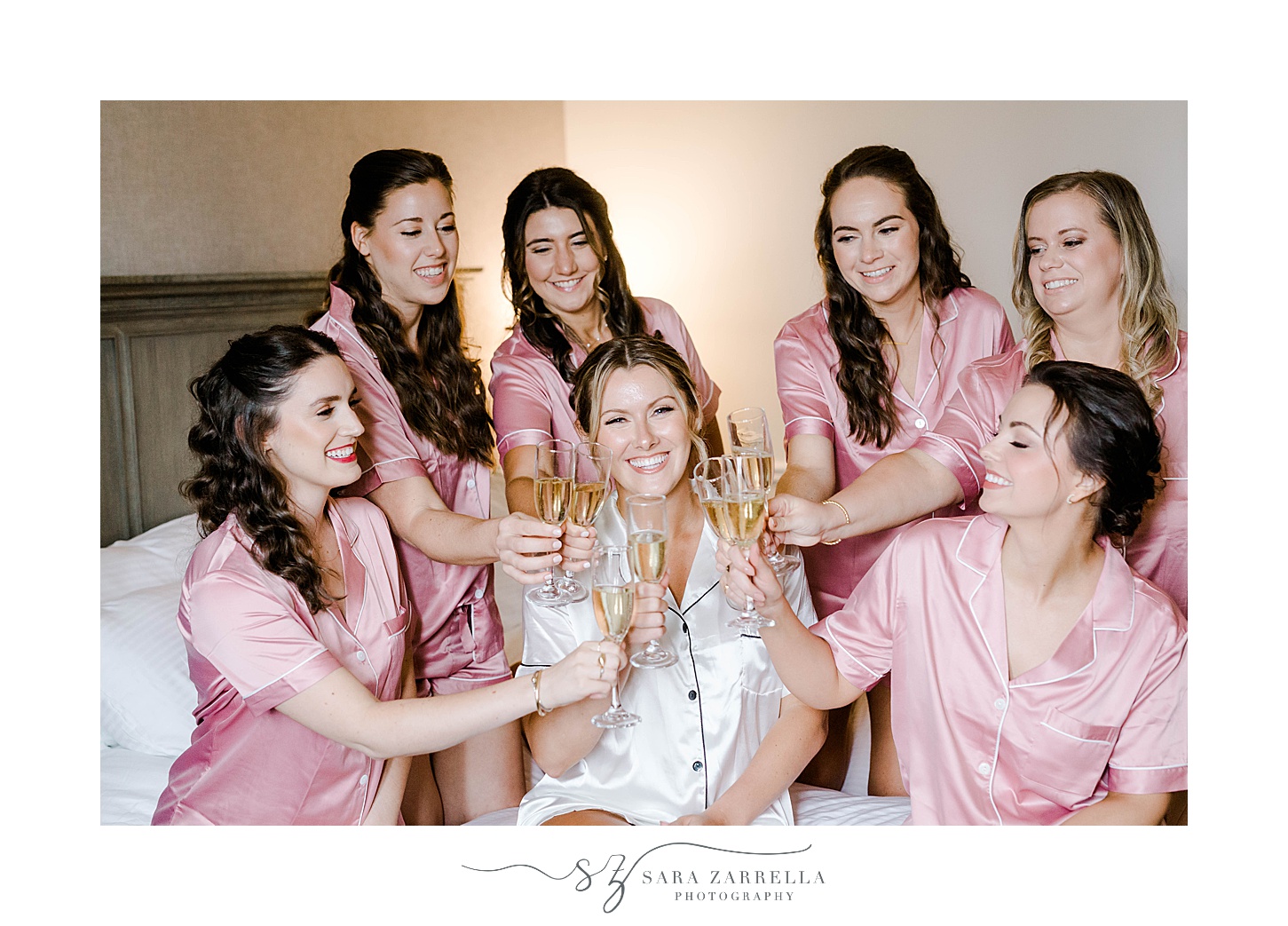 bridesmaids hold champagne glasses cheering with bride