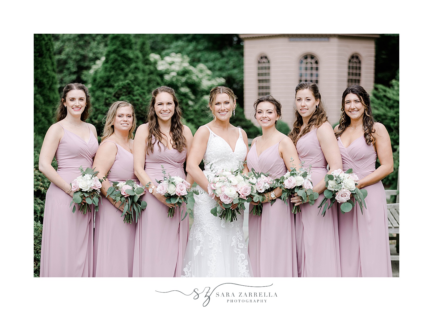 bride stands with bridesmaids in pink gowns in Newport RI
