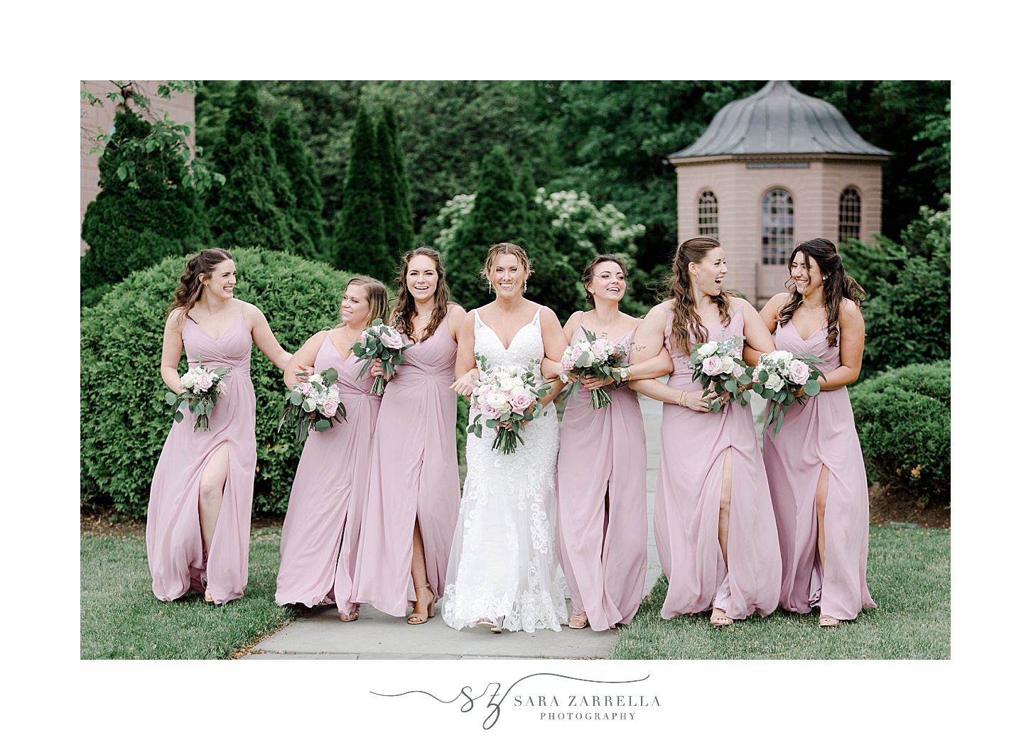 bride and bridesmaids in pink dresses stand together in Newport RI