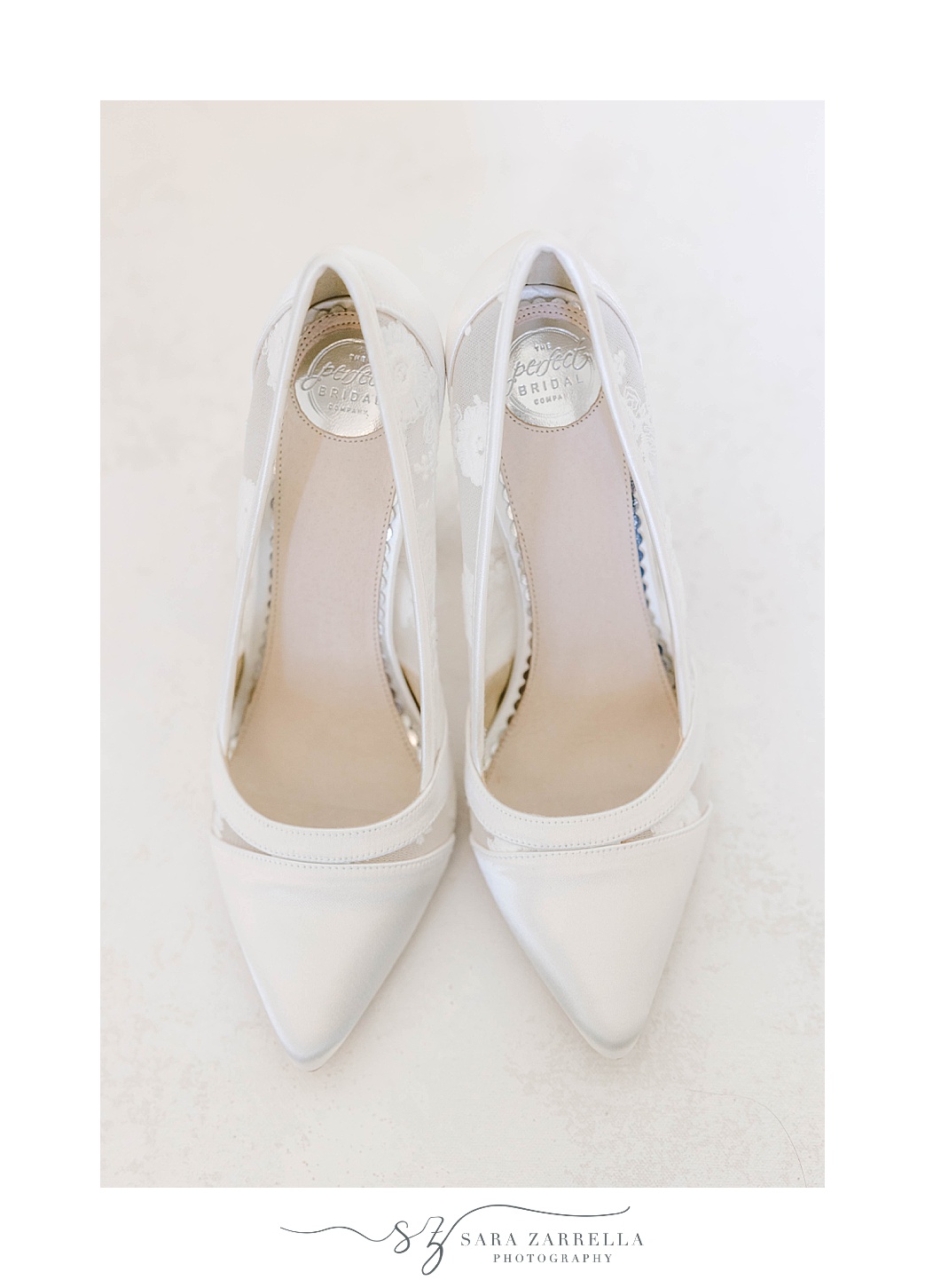 bride's white shoes with bows on back