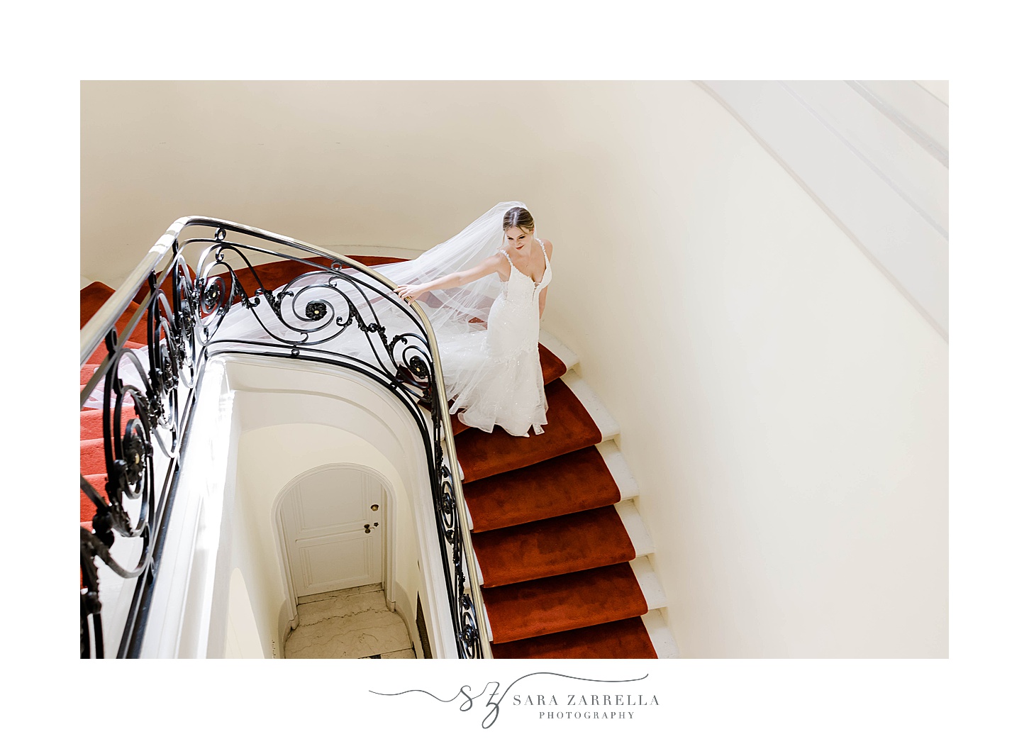 bride walks down red carpet on stairs at Glen Manor House