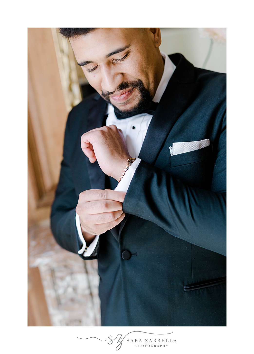 groom adjusts cufflinks before summer wedding day