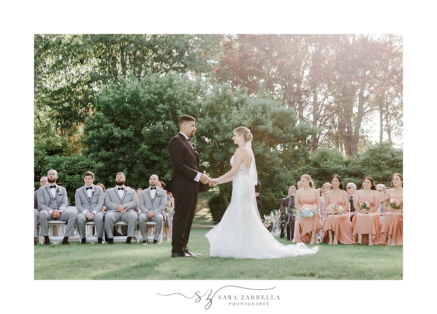 bride and groom hold hands during wedding ceremony on lawn at Glen Manor House
