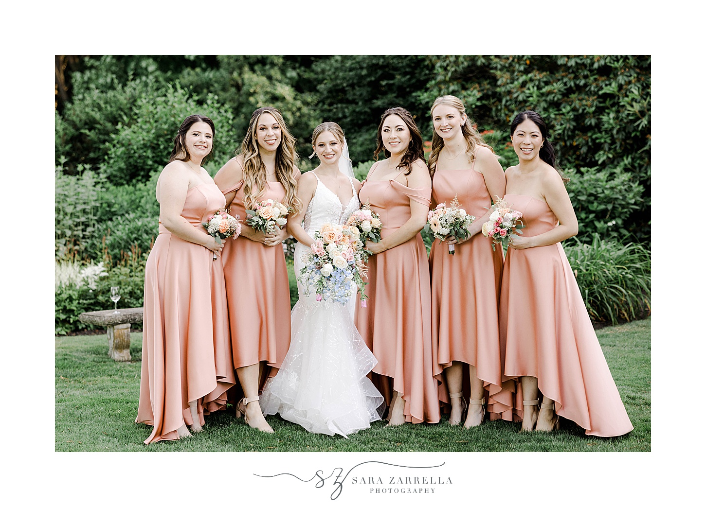 bride and bridesmaids in pink gowns stand together on lawn at Glen Manor House