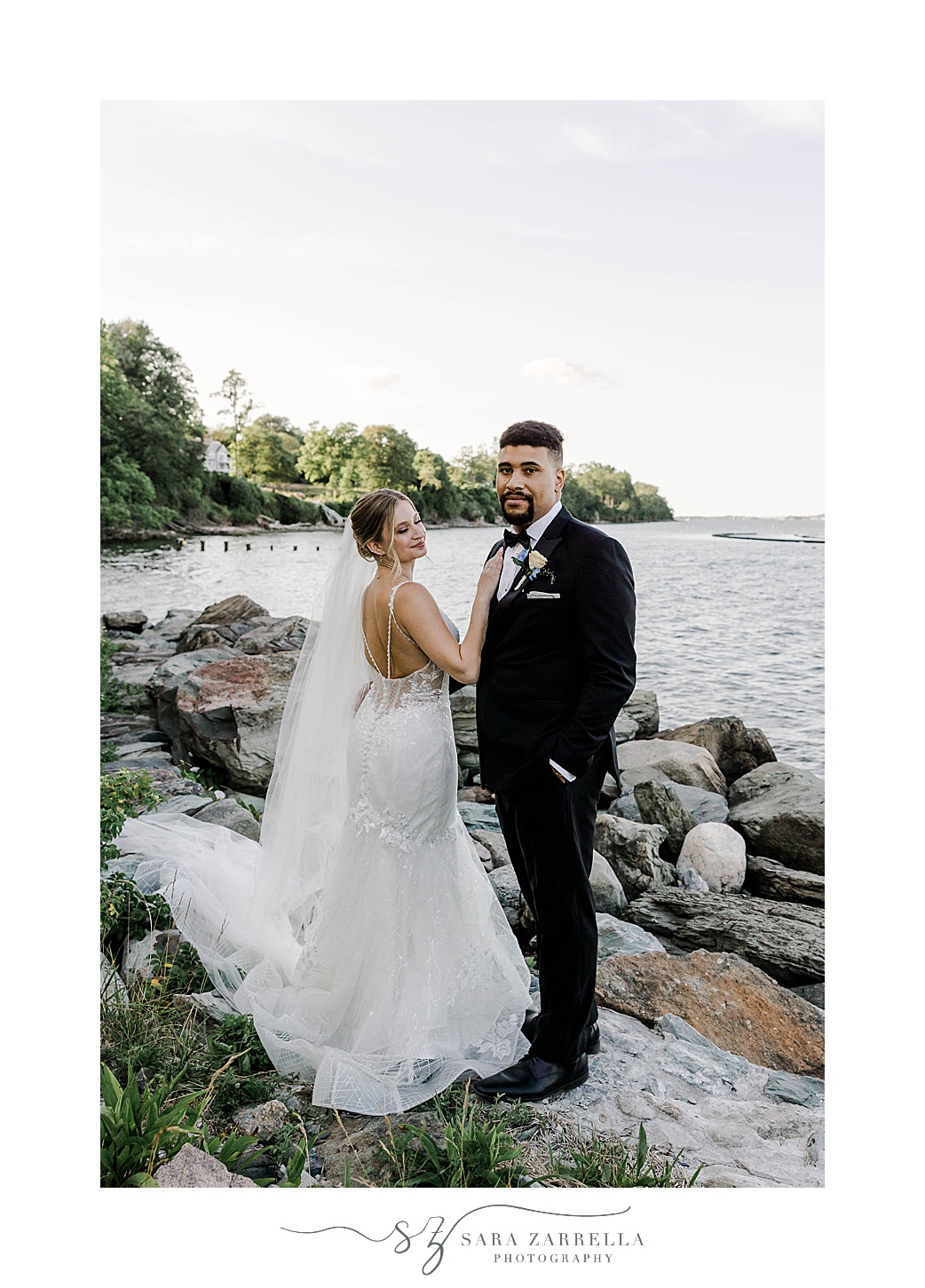 bride and groom stand by waterfront in Rhode Island
