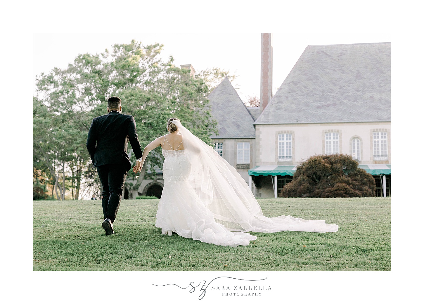 newlyweds hold hands walking on lawn at Glen Manor House