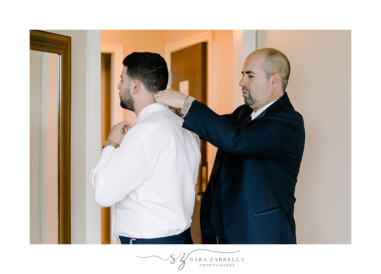 groomsman adjusts bowtie for groom before summer Lake of Isles wedding