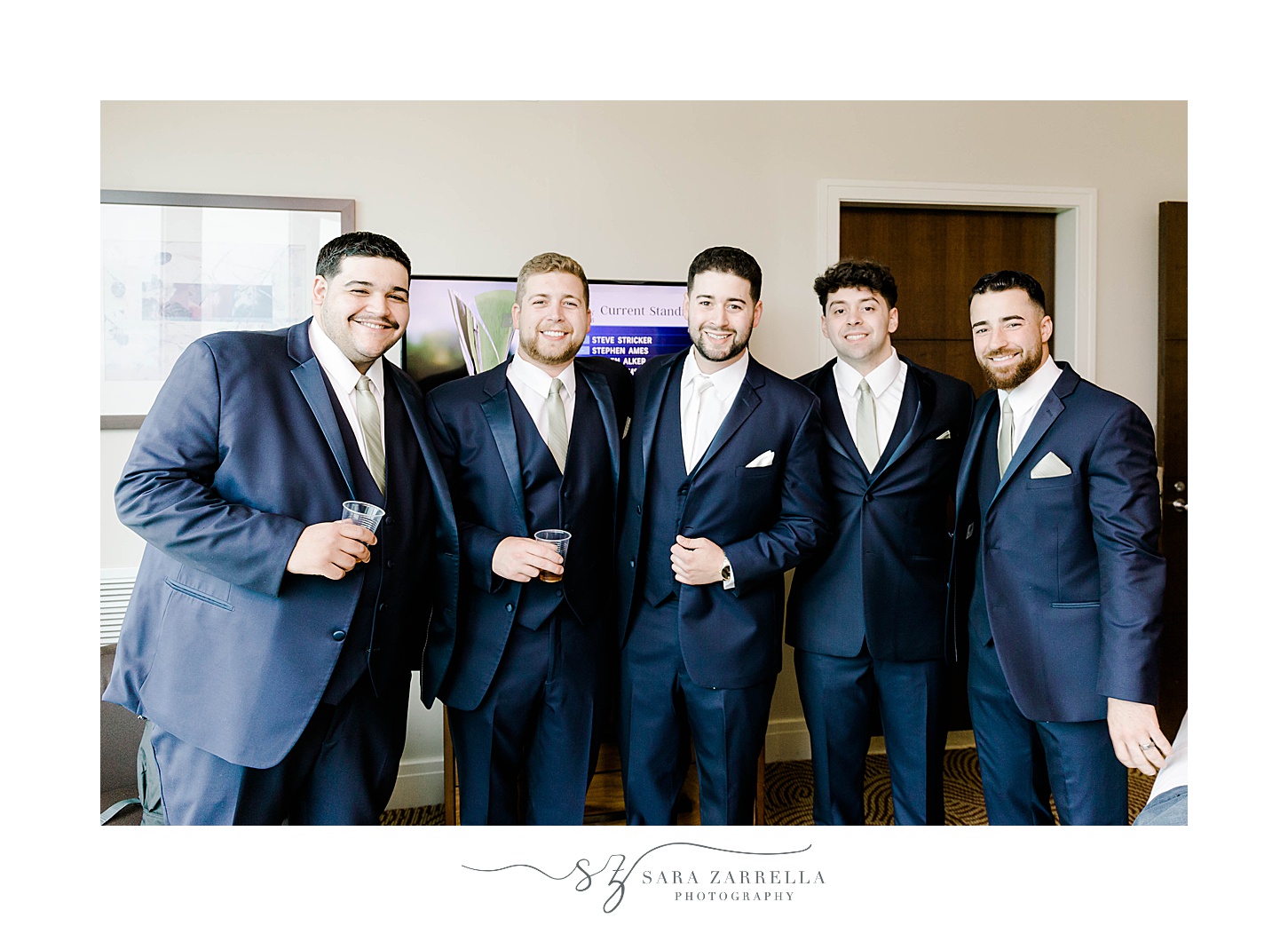 groom and groomsmen in navy suits with white pocket squares 