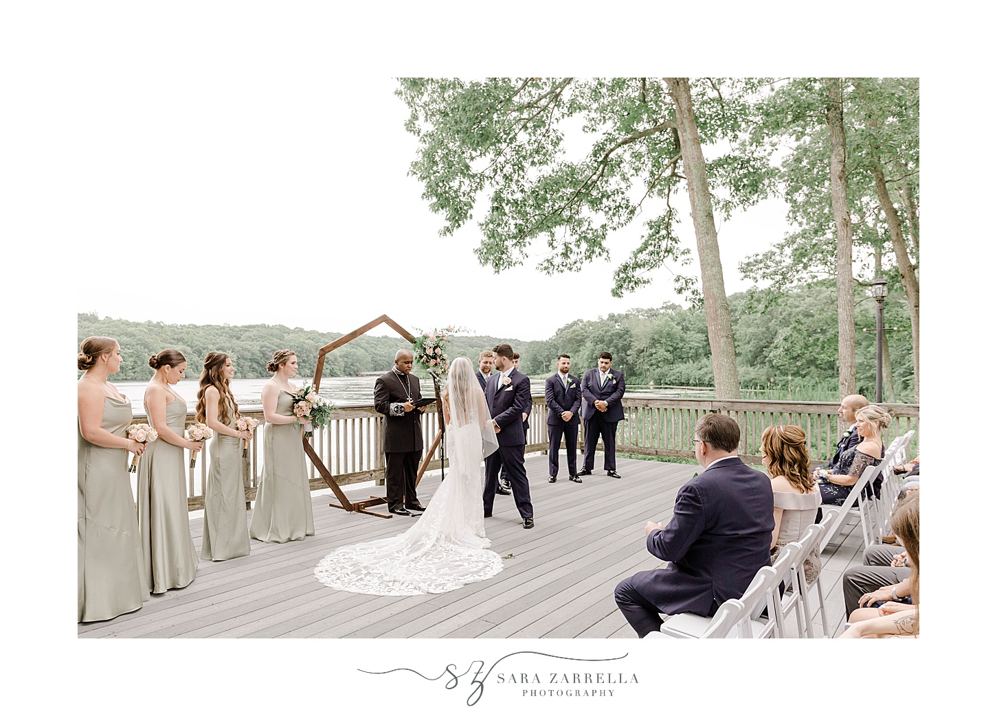 newlyweds hug in front of wooden arbor on dock at Lake of Isles