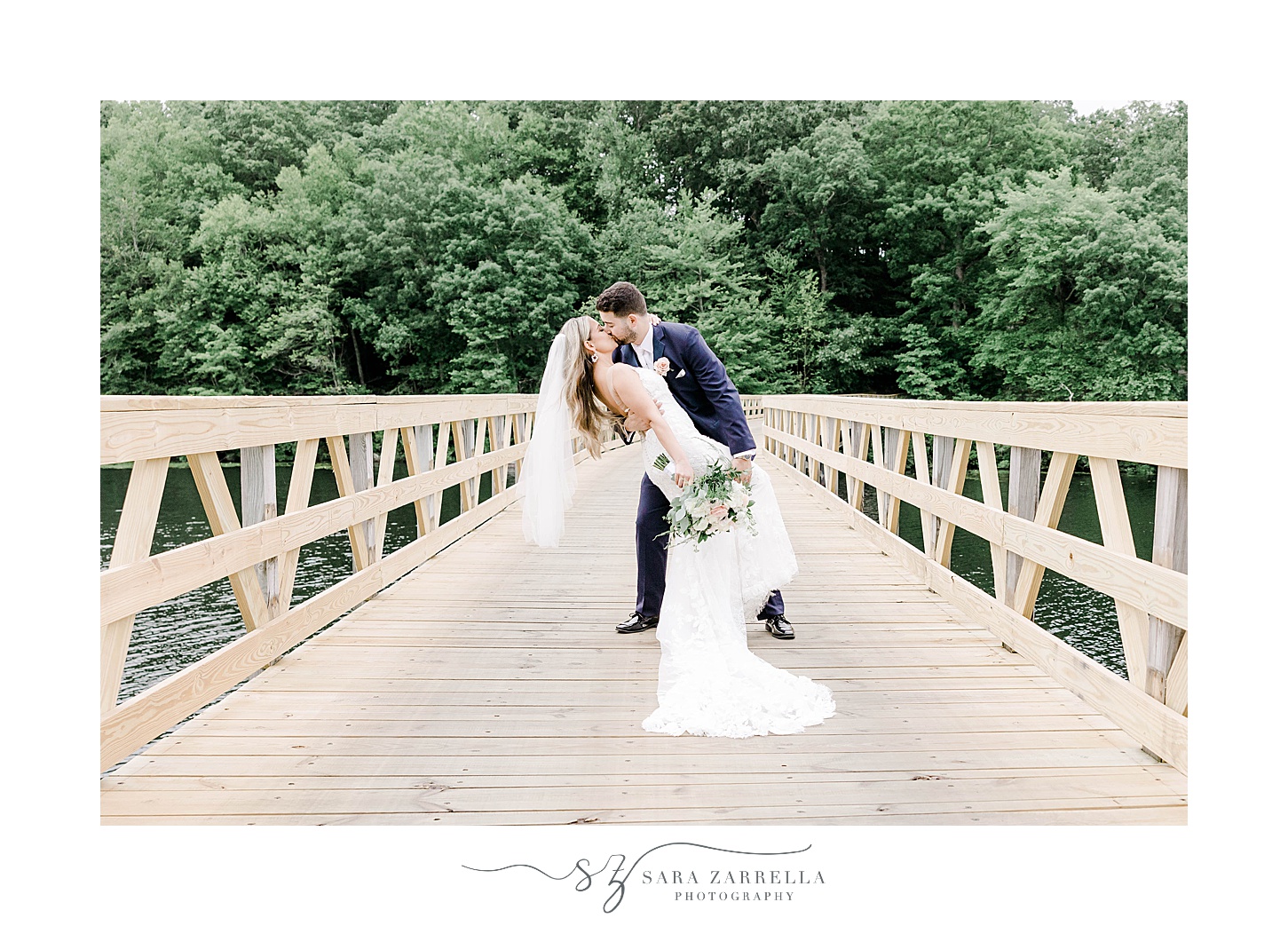 groom dips bride during kiss at Lake of Isles on wooden dock
