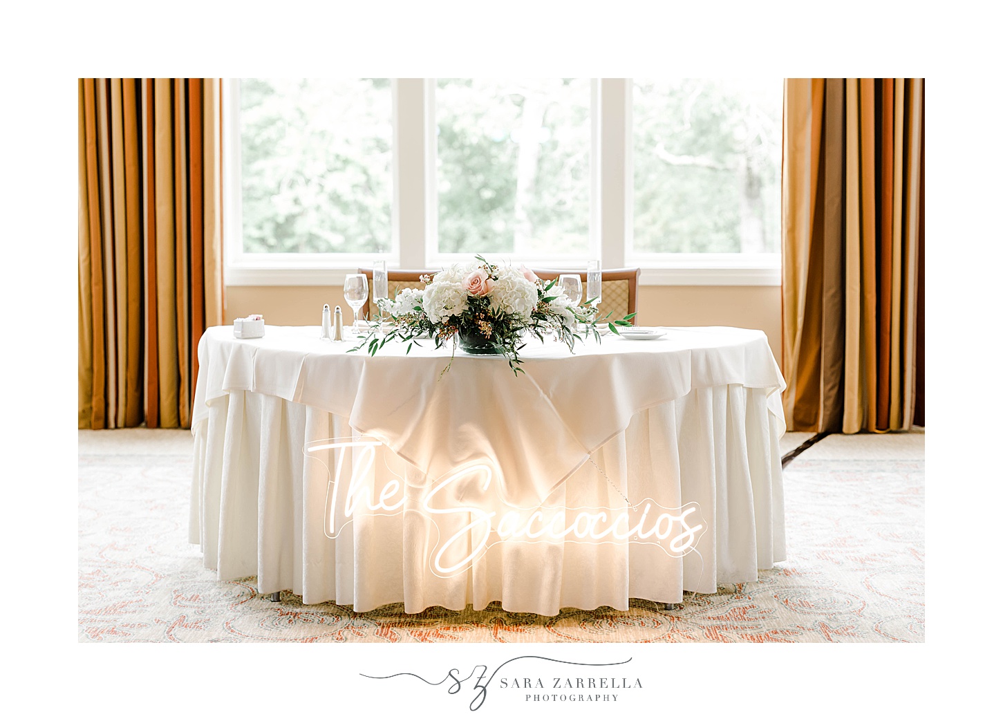 sweetheart table with custom neon sign in front at Lake of Isles