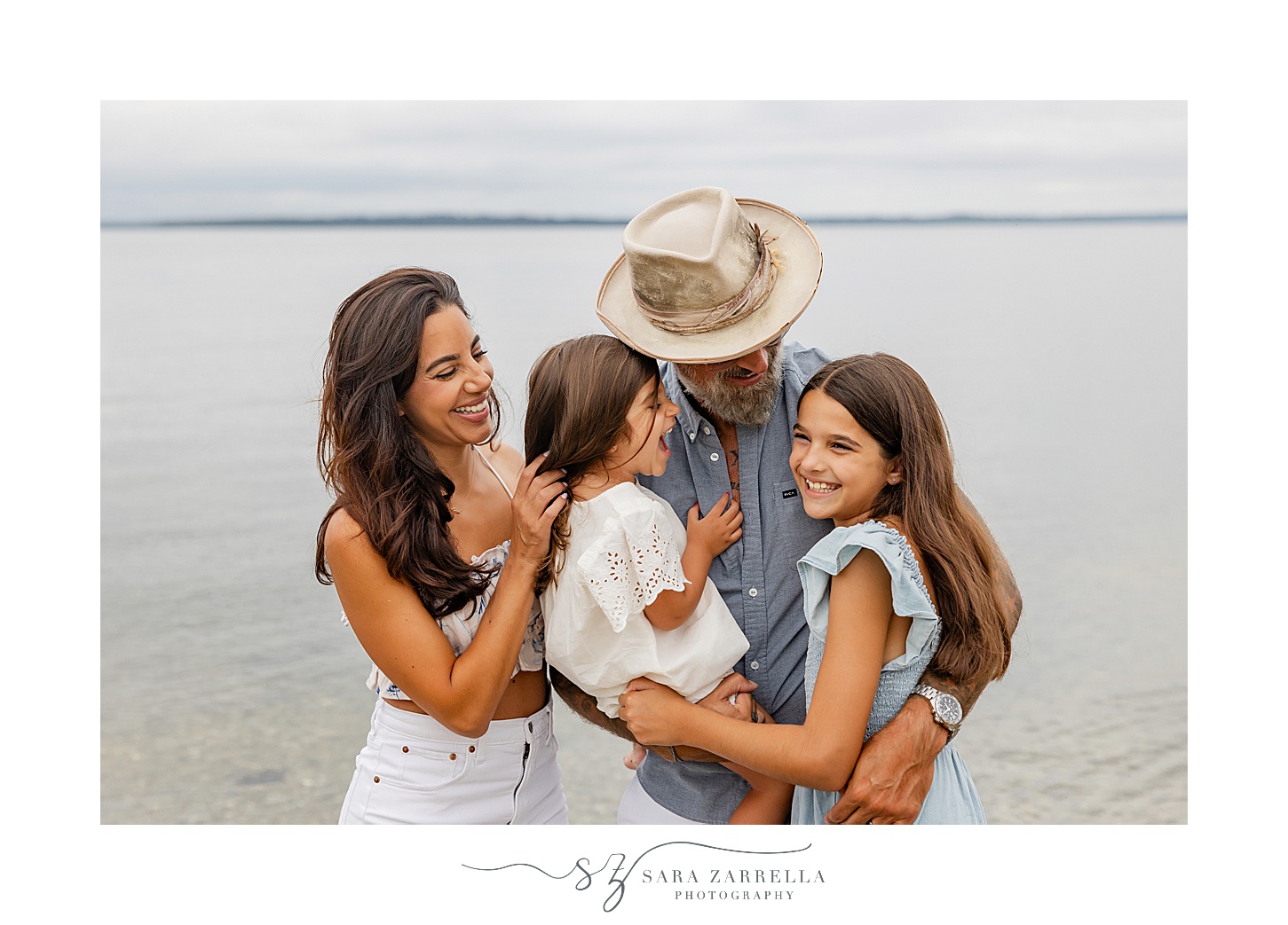 family hugs and looks at each other during Beach mini sessions in Newport RI