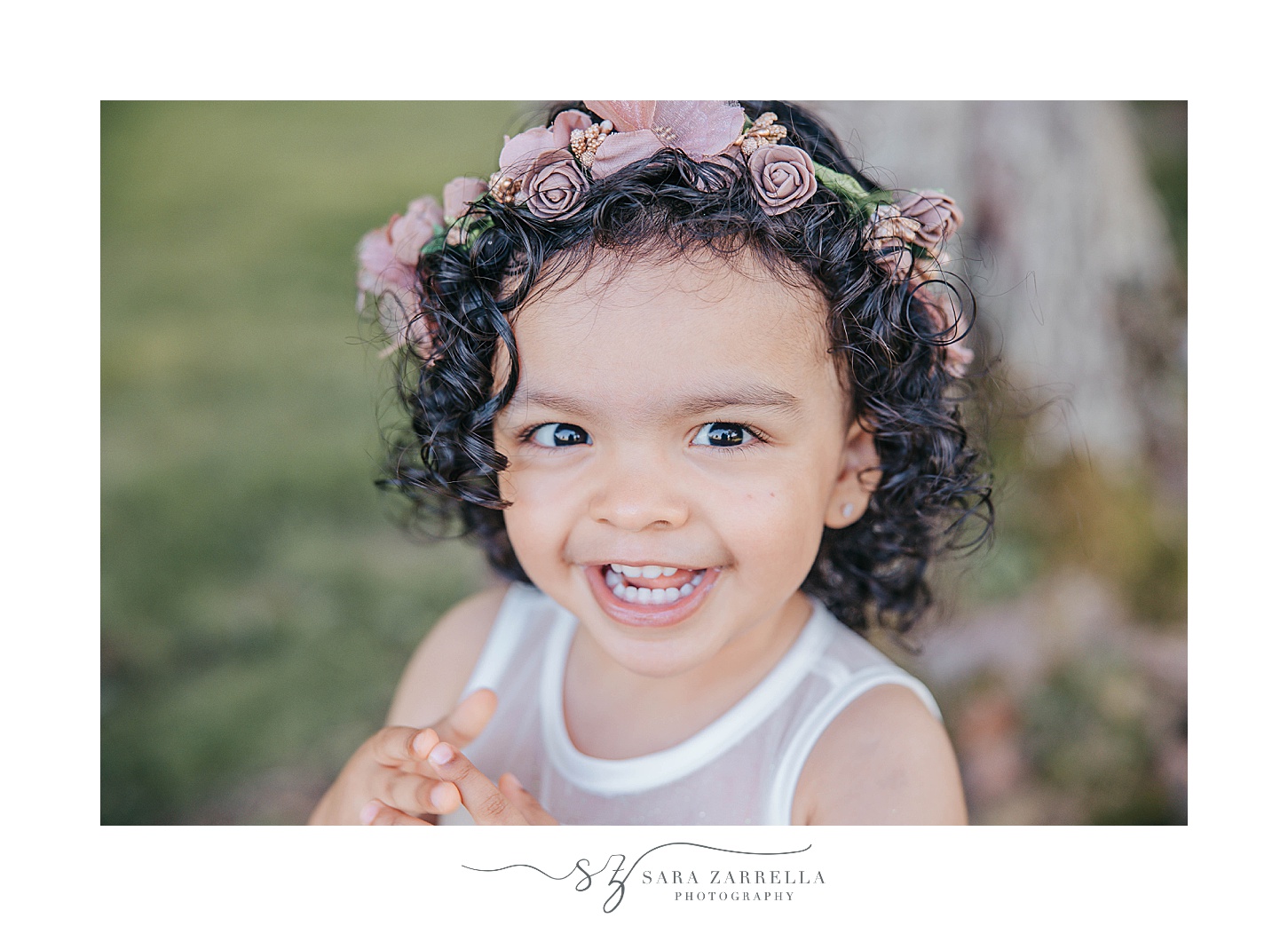 girl in purple flower crown laughs during summer mini session on farm in Rhode Island