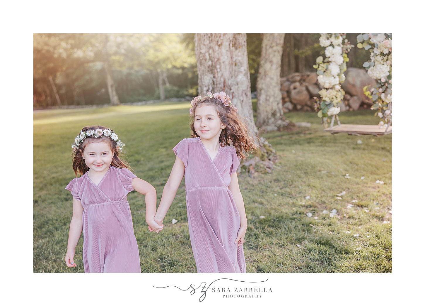 sisters in blue dresses hold hands running during summer mini session on farm in Rhode Island