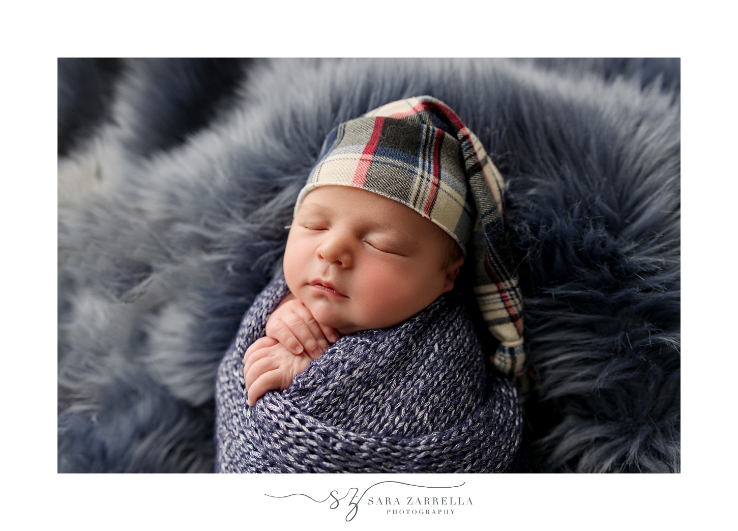 baby boy sleeps in blue wrap in plaid hat during newborn session with Rhode Island newborn and family photographer Sara Zarrella Photography