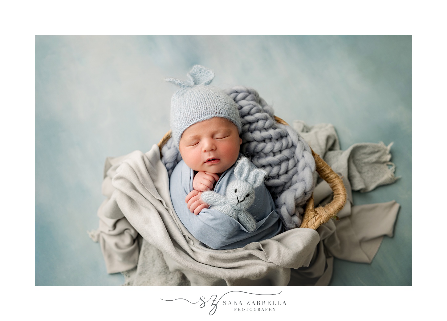 baby boy sleeps in basket during newborn session with Rhode Island newborn and family photographer Sara Zarrella Photography