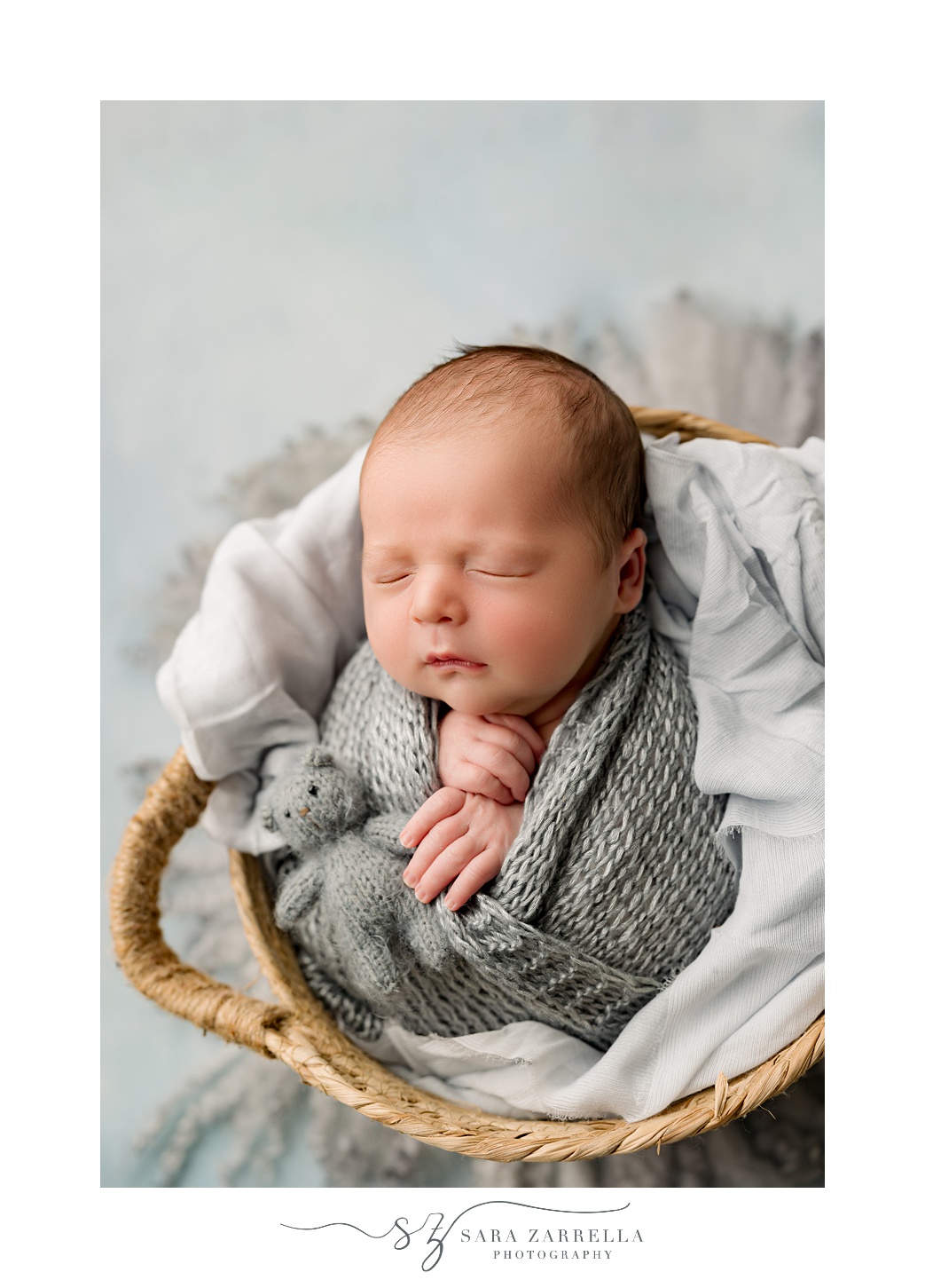 baby boy in grey wrap sleeps during newborn session with Rhode Island newborn and family photographer Sara Zarrella Photography