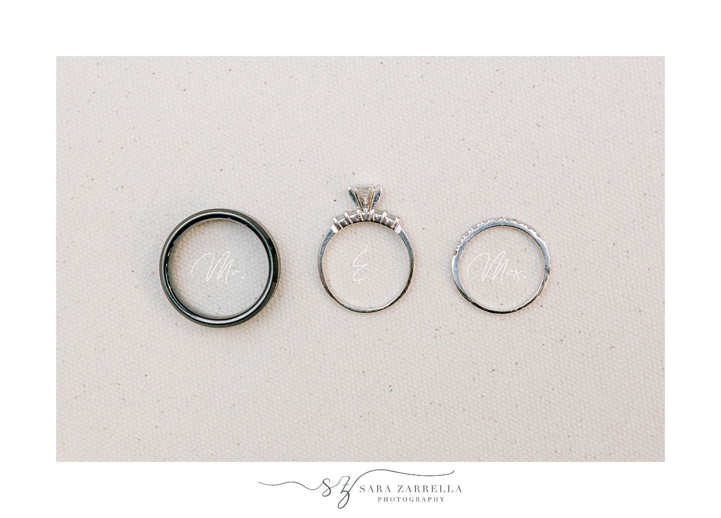 wedding rings lay on ivory backdrop with Mr and Mrs under bands 