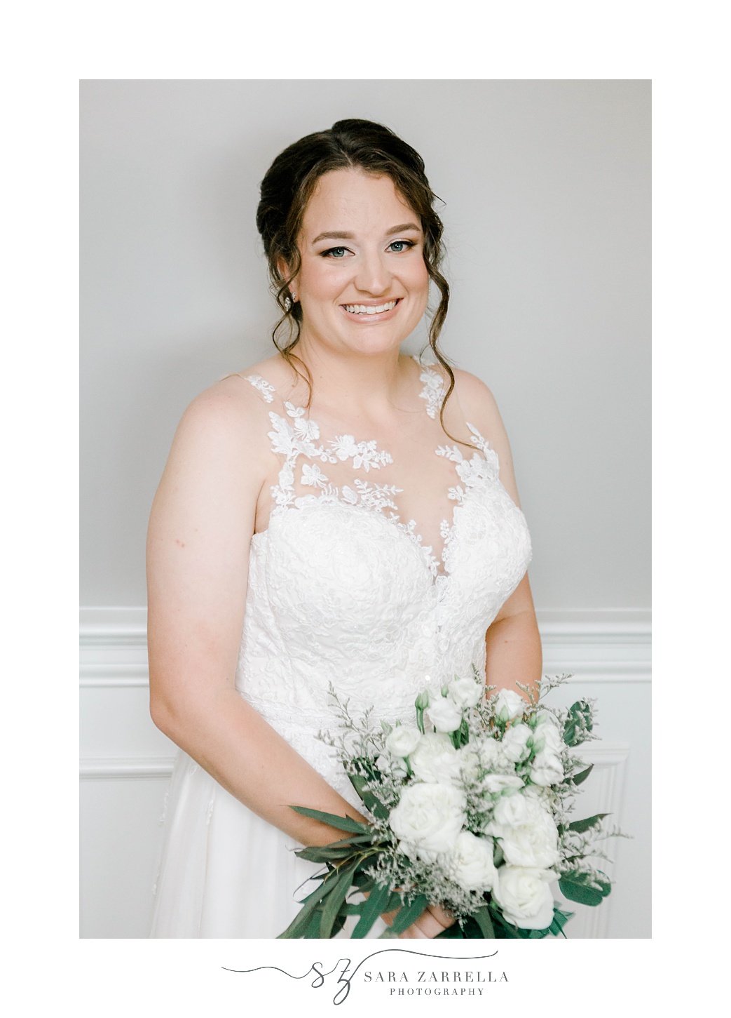 bride holds bouquet of white flowers inside Harbor Lights in lace detailed wedding gown