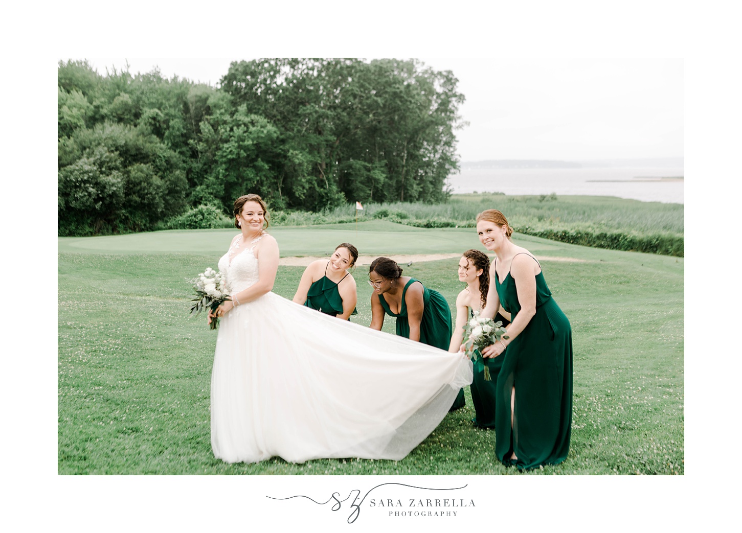 bridesmaids in green dresses help bride with train of wedding gown at Harbor Lights