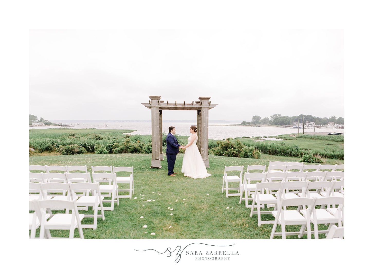 bride and groom pose at end of aisle at Harbor Lights 