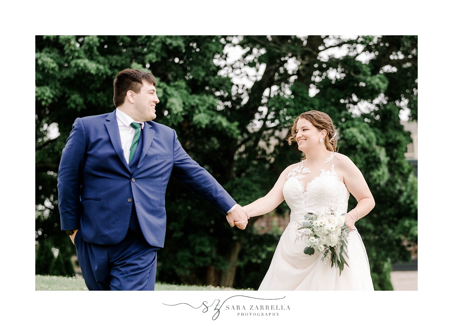 groom turns to look at bride walking with her across hill at Harbor Lights 