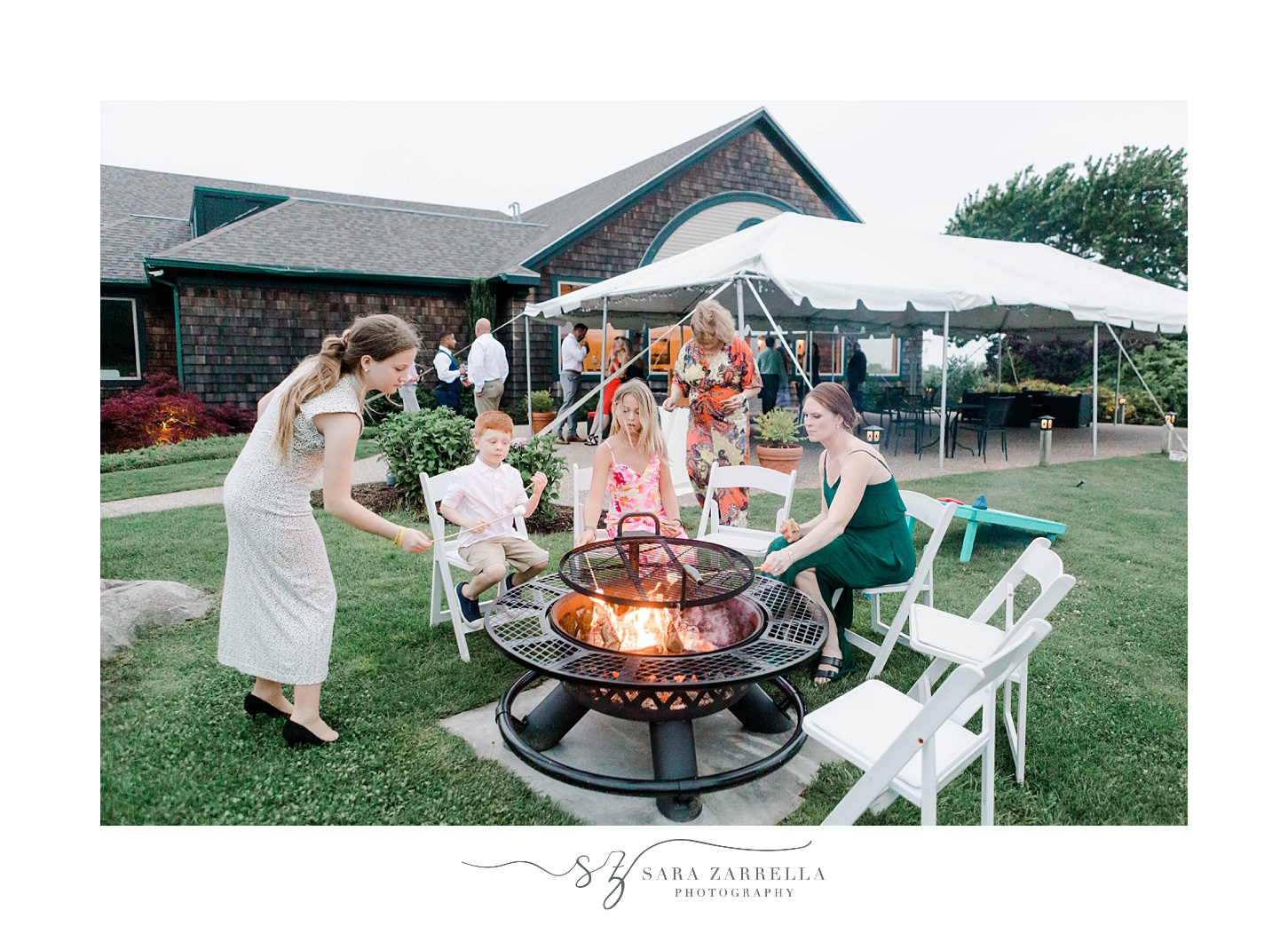 wedding guests mingle around s'mores campfire at Harbor Lights