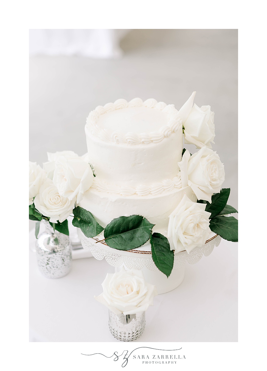 tiered wedding cake with white icing and roses 