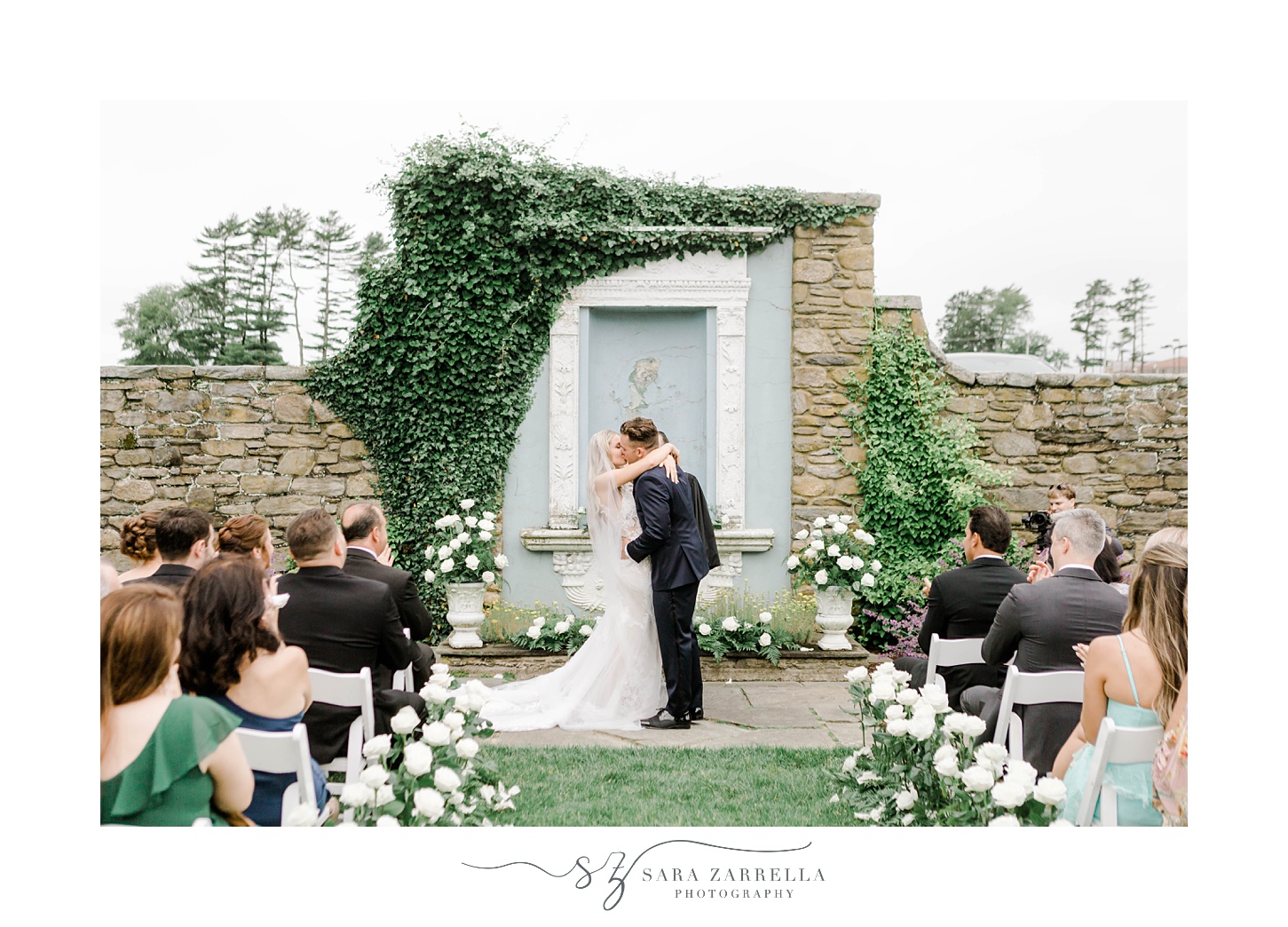 newlyweds kiss in garden within stone walls of Shepard's Run