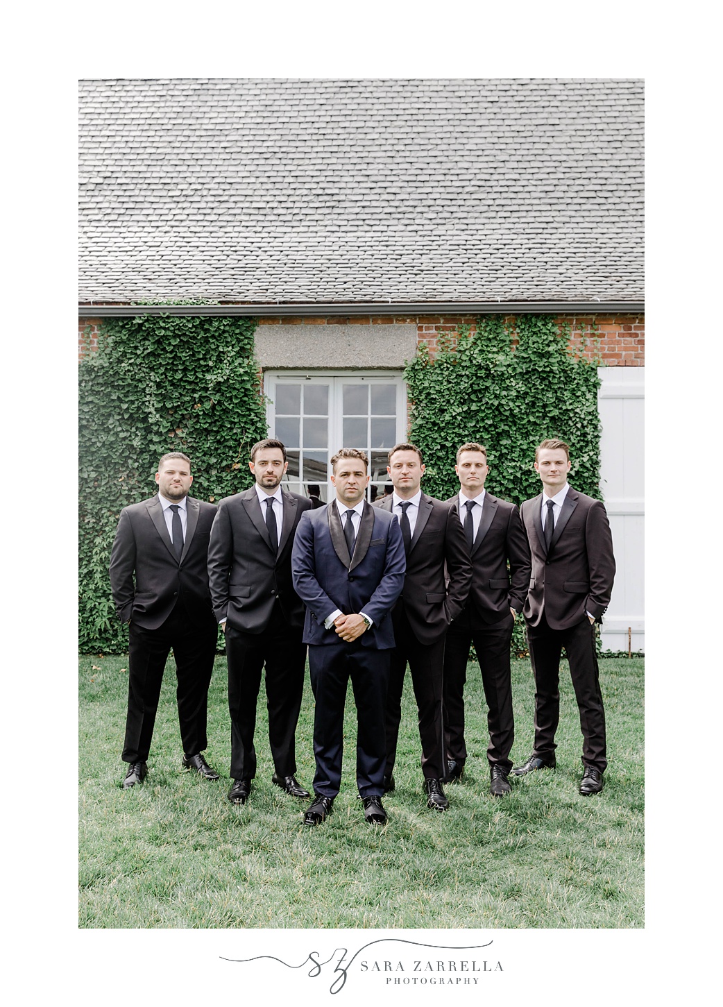 groom in navy suit stands with groomsmen in black suits at Shepard's Run