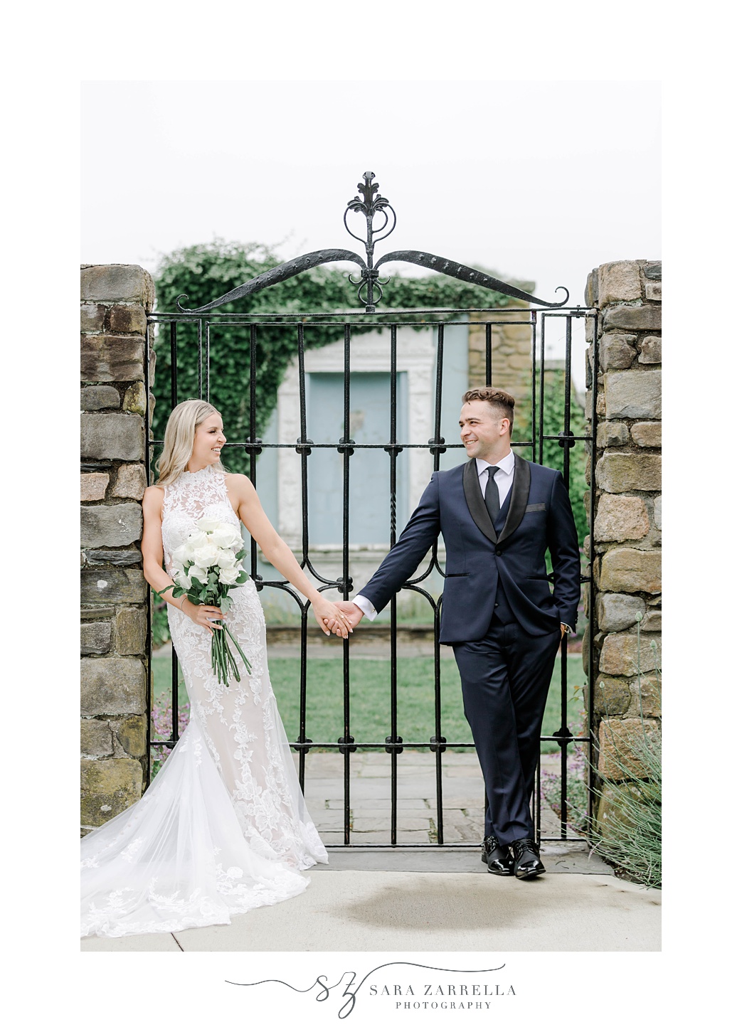 bride and groom hold hands in front of wrought iron fence at Shepard's Run