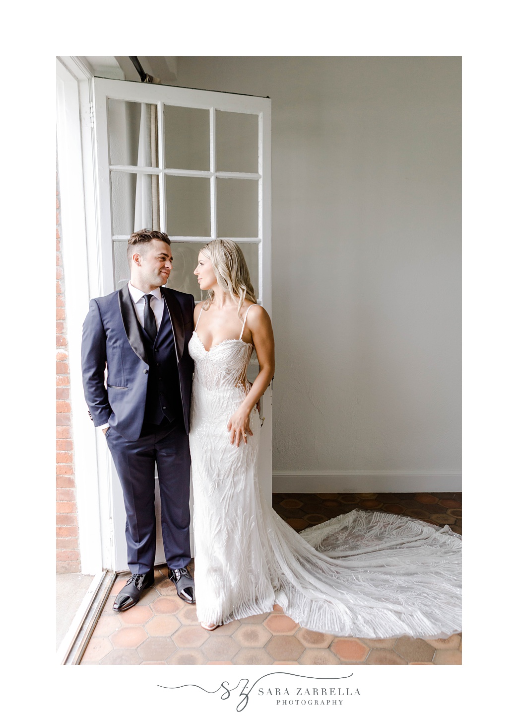 bride and groom lean against open door in Rhode Island venue 