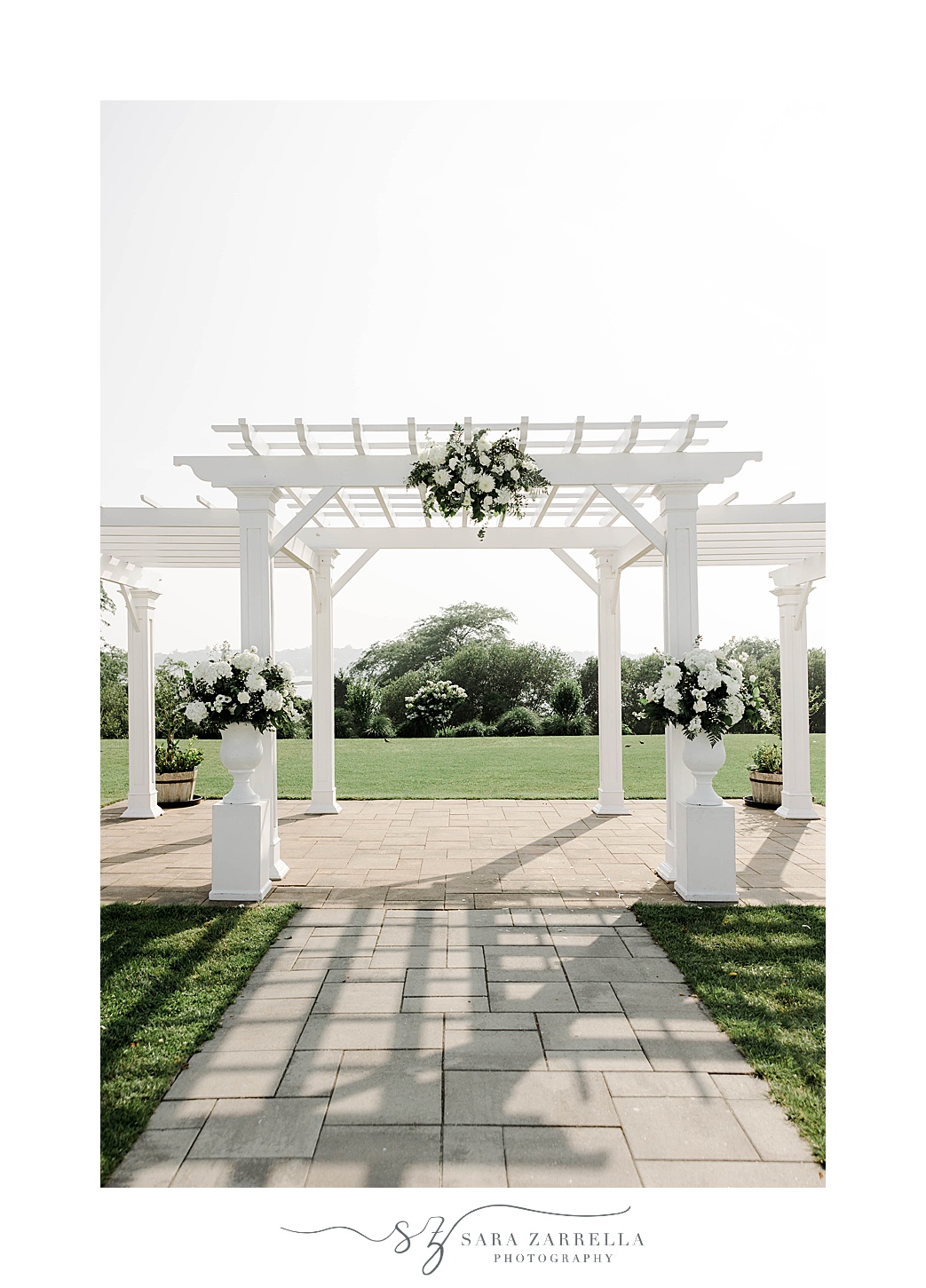white arbor with flower arrangement hanging near top