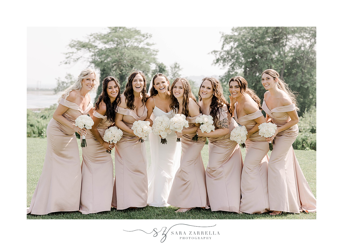bride and bridesmaids smile holding all white bouquets in pink gowns 