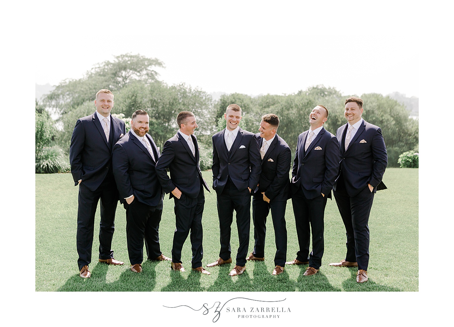 groom and groomsmen stand together on lawn at the Wyndham Newport Hotel
