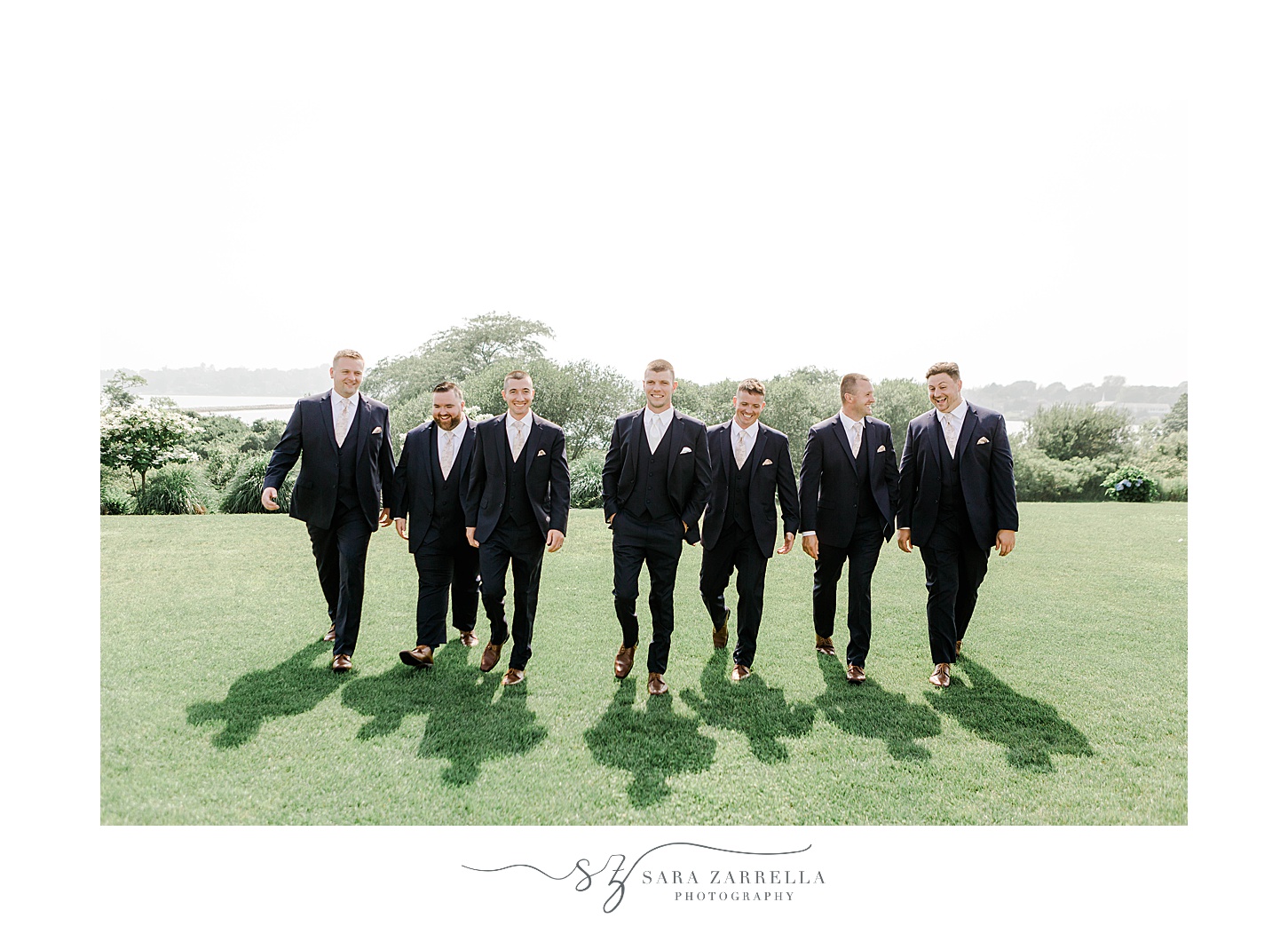 groom and groomsmen walk on lawn at the Wyndham Newport Hotel
