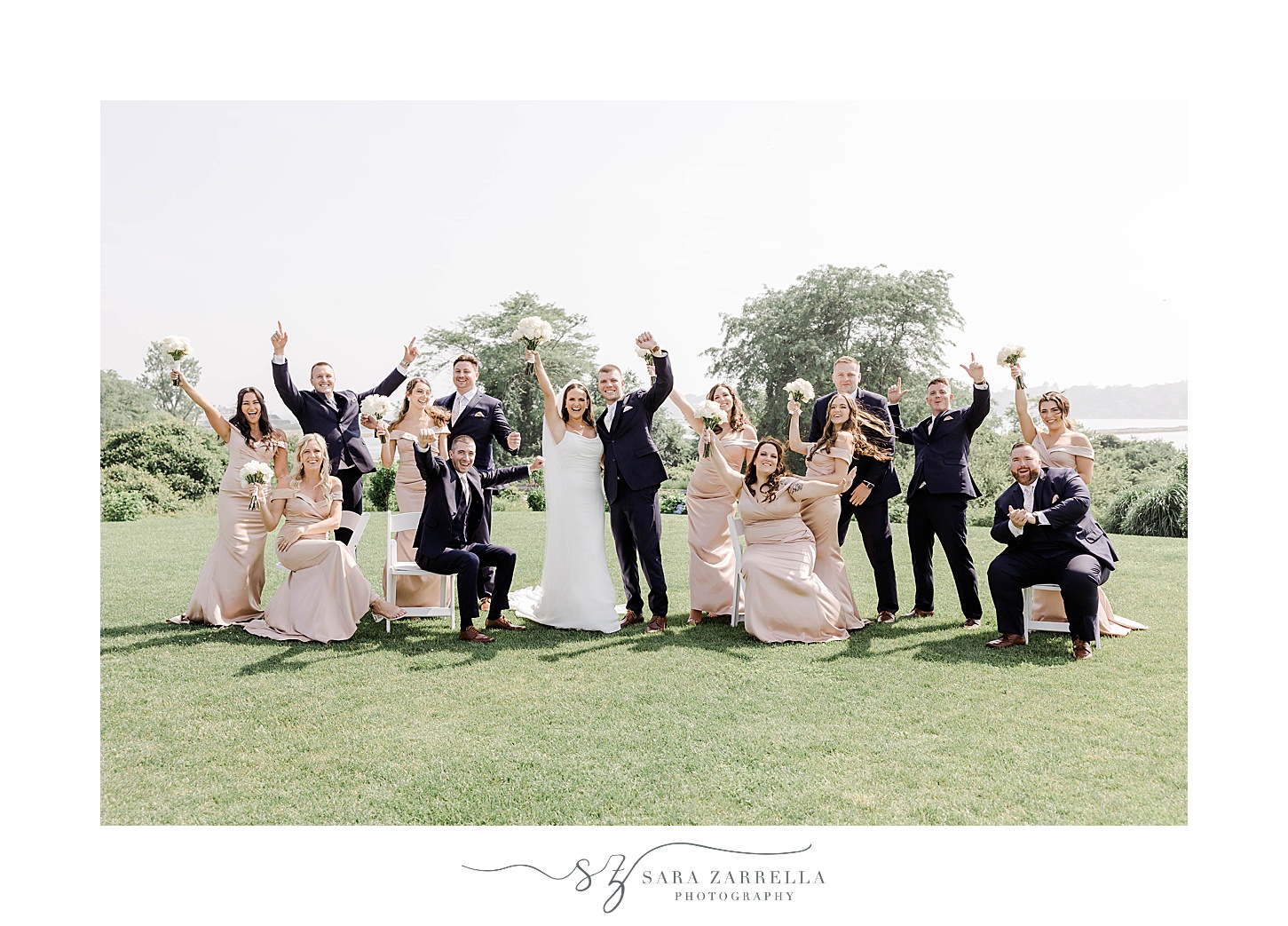 bride and groom cheer with wedding party in pink and navy attire 