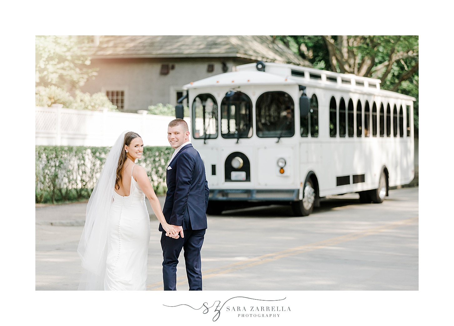 bride and groom hold hands walking to white trolley 
