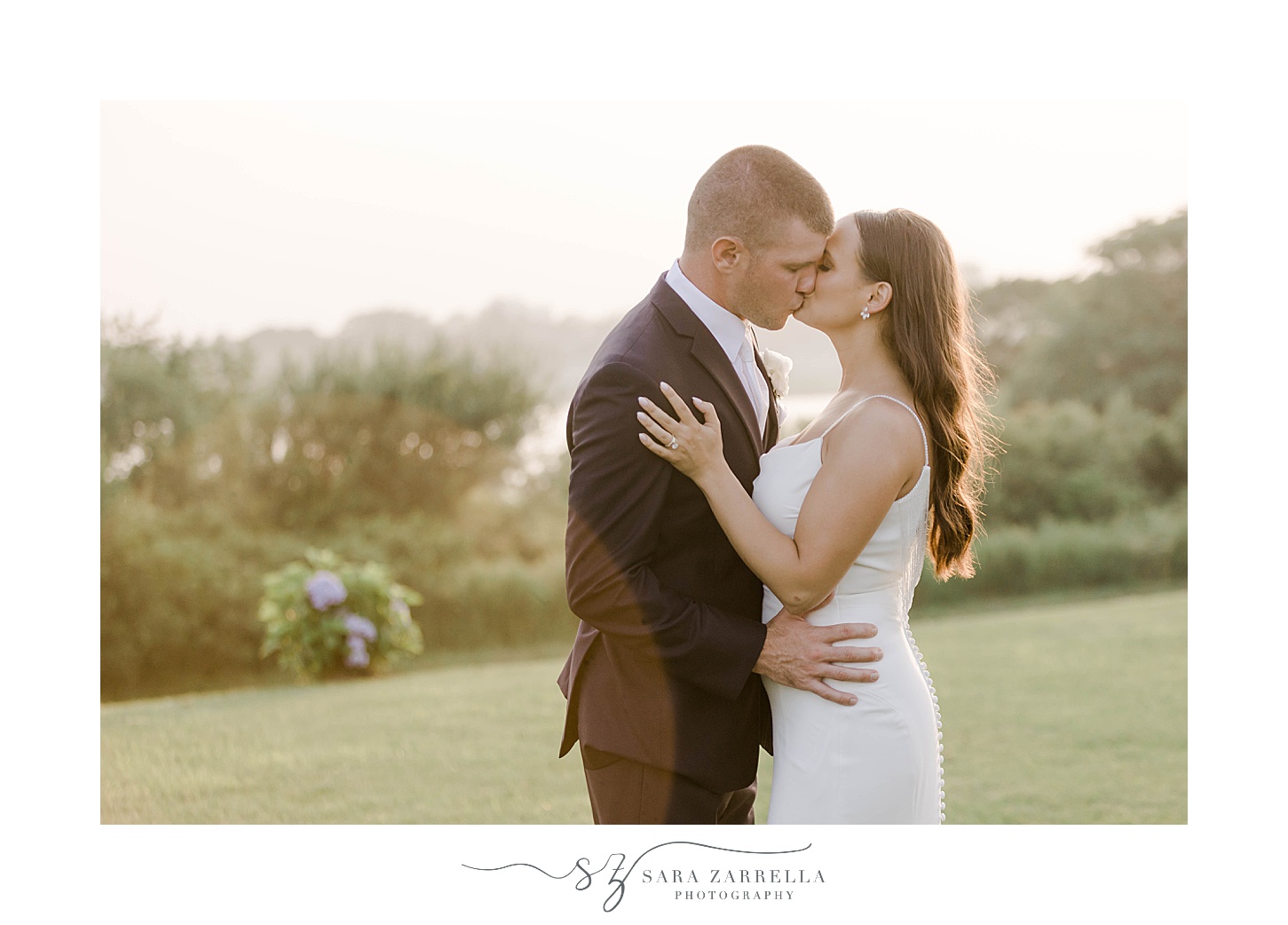 bride and groom kiss at sunset on lawn at the Wyndham Newport Hotel