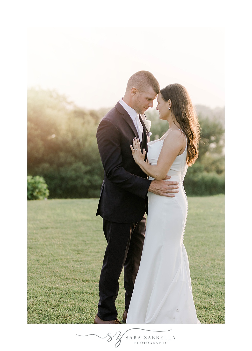 newlyweds hug at sunset on lawn at the Wyndham Newport Hotel