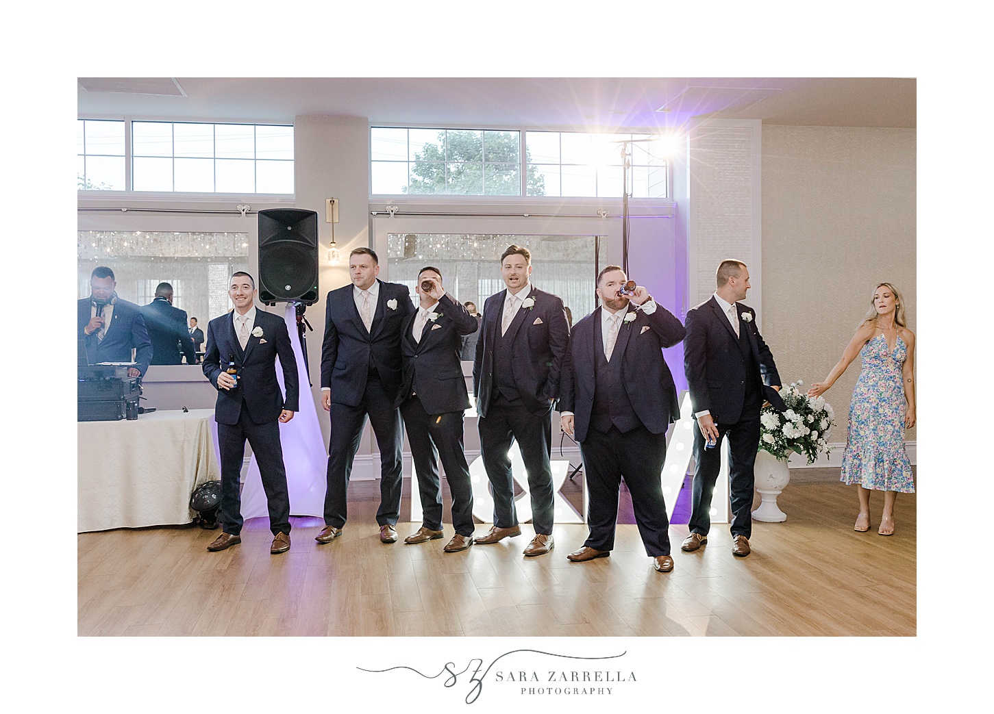 groomsmen stand on edge of dance floor to welcome newlyweds 