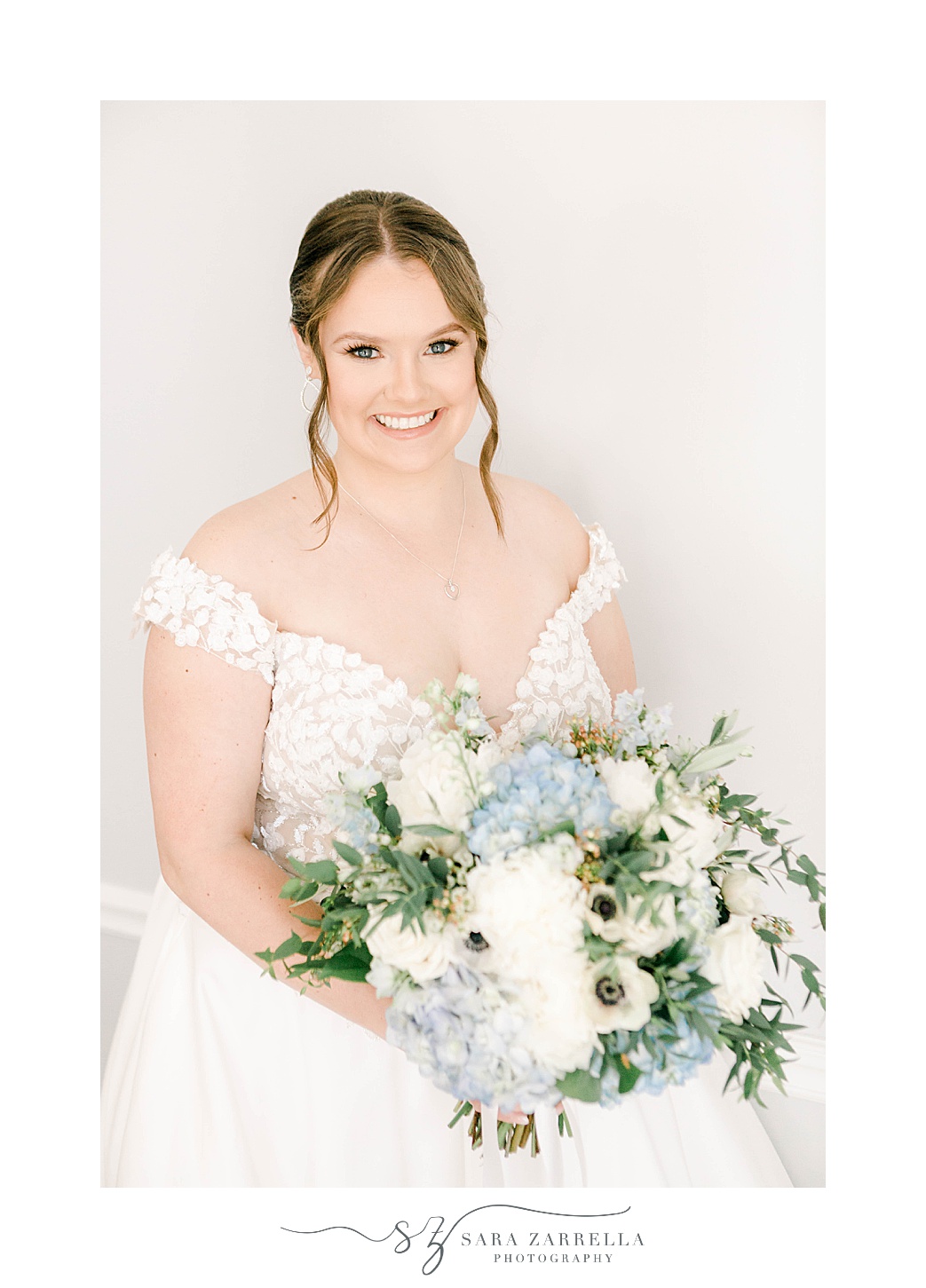 bride holds bouquet of white and blue flowers before coastal Newport Harbor Island Resort wedding