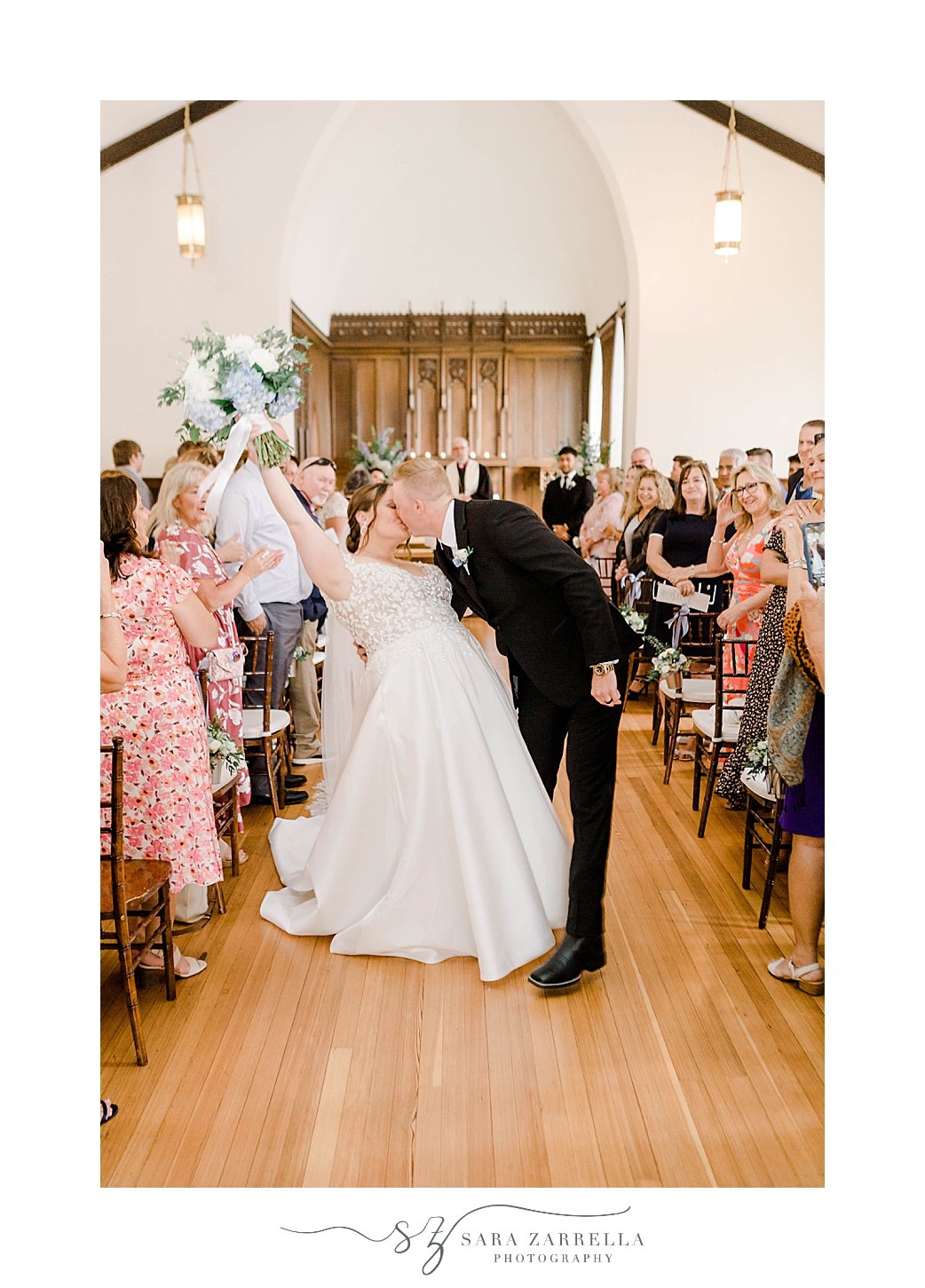 bride and groom kiss in aisle after wedding ceremony at Kay Chapel in Newport RI